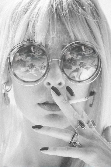 Glamour Hippie – portrait en noir et blanc d'une femme portant des lunettes de soleil rondes et une cigarette