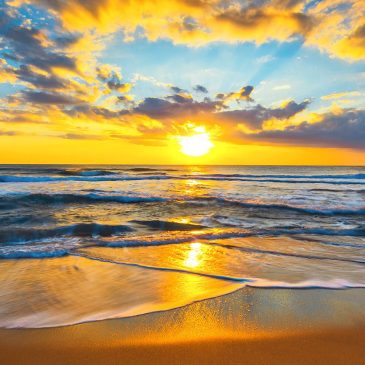 Beach photo with a radiant sunrise