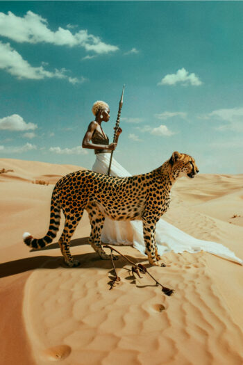 Hermosa mujer africana en el desierto con guepardo