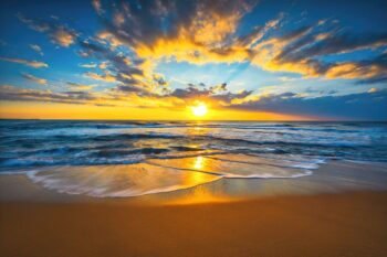 Photo de plage avec lever de soleil rayonnant